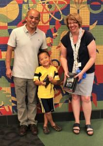 Edward Li is the winner of the Kids Summer Reading Program Grand Pirze, a Kindle Fire. He is pictured with his father, Richard Li, and Vickie Pasicznyk, the Children