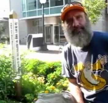 A photo of Scott Koepke next to the Peace Pole in the IC Children's Garden